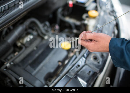 Überprüfen den Ölstand im Motor eines Autos Mechaniker Stockfoto