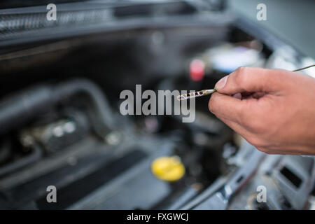 Überprüfen den Ölstand im Motor eines Autos Mechaniker Stockfoto