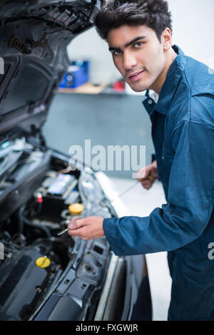 Überprüfen den Ölstand im Motor eines Autos Mechaniker Stockfoto