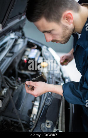 Überprüfen den Ölstand im Motor eines Autos Mechaniker Stockfoto