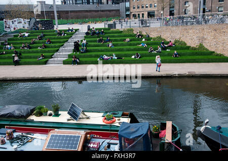 London. Kings Cross. Kanal mit Central St Martins Kunstschule in den Hintergrund und die Leute saßen auf Bank-Terrassen Stockfoto