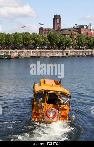 Gelbe "Ente" Amphibienfahrzeug führt Touristen auf Liverpool Docks mit der anglikanischen Kathedrale ist in der Ferne. Stockfoto