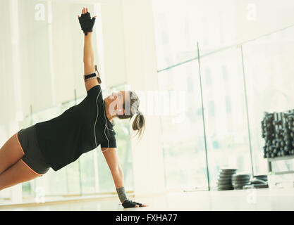 Frau Auswuchten in Seite Planke im Fitness studio Stockfoto