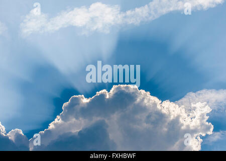 Erstaunliche Strahlen der Sonne hinter den Wolken, blauer Himmel Coming-out Stockfoto