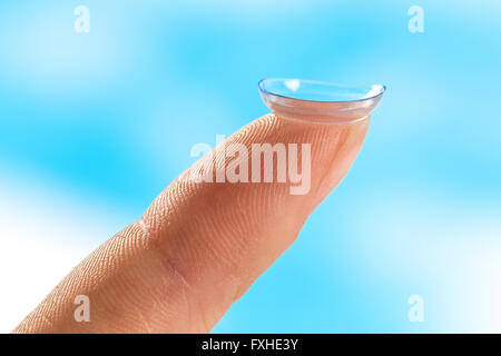 Kontaktlinse auf Finger-Tipp blauen Hintergrund Stockfoto