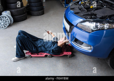Weibliche Mechaniker, die Reparatur eines Autos Stockfoto