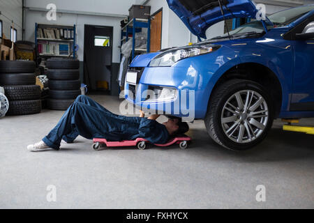 Weibliche Mechaniker, die Reparatur eines Autos Stockfoto