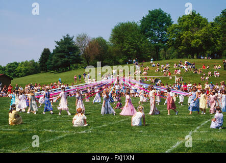 Grundschulkinder tanzen um den Maibaum; Maifeiertag Stockfoto