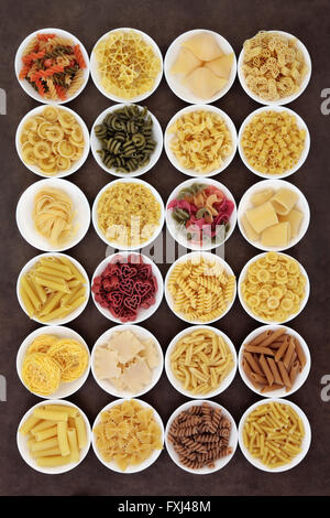 Große italienischer Pasta Auswahl an Speisen in Runde Schalen über braunen Hintergrund getrocknet. Stockfoto