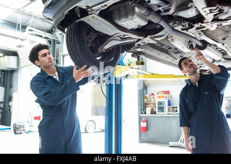 Festsetzung eines Rades während ein Kollege Prüfung Auto Mechaniker Stockfoto