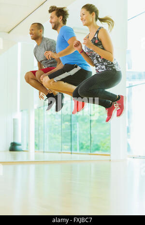 Begeisterte Männer und Frauen springen in Übung zur Vorlesung Stockfoto