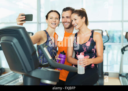 Lächelnden Freunde nehmen Selfie am Heimtrainer im Fitness-Studio Stockfoto