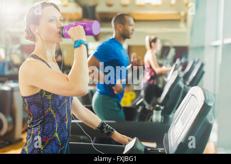 Frau am Laufband Trinkwasser Stockfoto