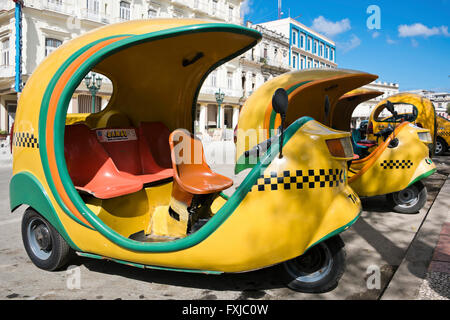 Horizontale Ansicht von Coco Taxis geparkt in einer Reihe in Havanna, Kuba. Stockfoto