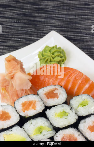 Nigiri Sushi, Maki-Rollen und Ingwer mit Wasabi auf einem Teller. Vertikal. Stockfoto