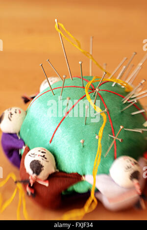 Nadelkissen mit kleinen Figuren der chinesischen Männer um ihn herum. Schuss mit Lensbaby für Tiefenschärfe. Stockfoto