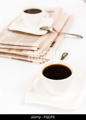 Zeitung und weißen Tasse Kaffee auf weißem Hintergrund Stockfoto