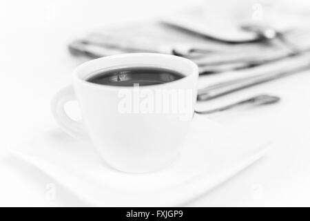 Zeitung und weißen Tasse Kaffee auf weißem Hintergrund Stockfoto