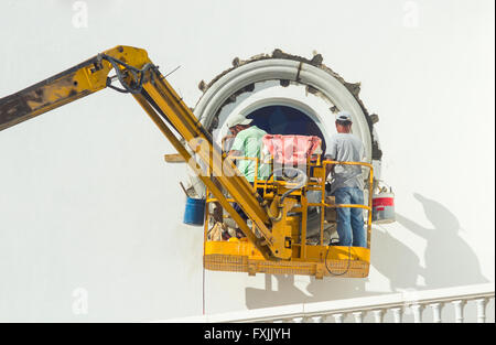 Arbeiter in Hubarbeitsbühnen Reparatur Kirchenfenster in Spanien Stockfoto