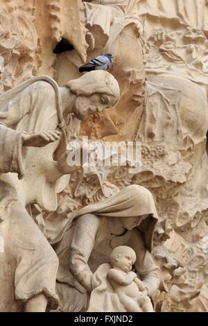 Aufwendigen Schnitzereien auf der Krippe Fassade der Sagrada Familia im Herzen von Barcelona, Spanien. Eine Taube ruht auf den Kopf des Stockfoto