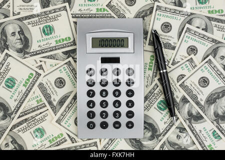 Taschenrechner und Kugelschreiber auf dem million Dollar liegen. als Hintergrund Stockfoto