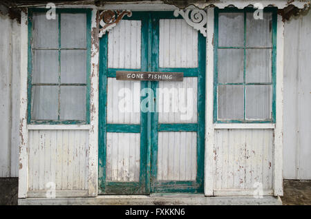 Weg Angler Schild hängen an zwei alte verwitterte grüne und weiße Türen mit gerissenen Malerei Stockfoto