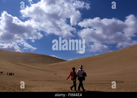 Jiuquan, Chinas Provinz Gansu. 16. April 2016. Menschen besuchen den Mondsichelsee Landschaft Stelle berühmte Berg von Dunhuang Stadt, Nordwesten Chinas Provinz Gansu, 16. April 2016. Dunhuang-Stadt zeigte seine natürliche Schönheit nach einem Regen am Samstag. Bildnachweis: Zhang Xiaoliang/Xinhua/Alamy Live-Nachrichten Stockfoto