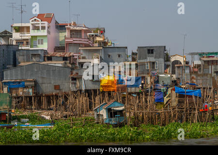 Traditionelle Häuser auf Stelzen mit der Stadt auf dem Land hinter, Mekong-Delta, Chau Doc, Vietnam. Stockfoto