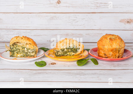 Hausgemachte Spanakopita - griechische Spinatpastete mit Feta und Ricotta, in Scheiben geschnitten auf Platten Stockfoto