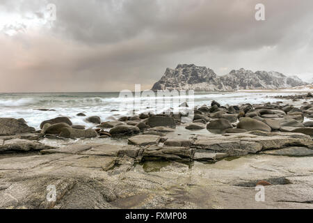 Wellen über Utakleiv Beach, Lofoten Inseln, Norwegen im Winter fließt. Stockfoto