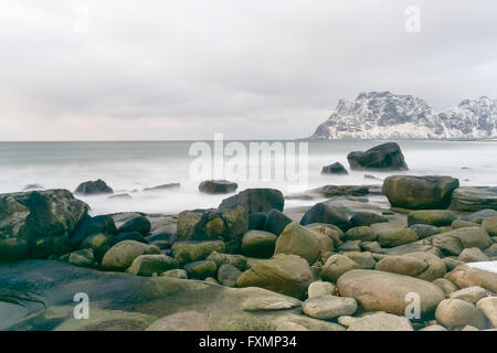 Wellen über Utakleiv Beach, Lofoten Inseln, Norwegen im Winter fließt. Stockfoto