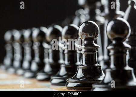 Schwarzen Schach Schachfiguren auf dem Brett in einer Reihe Stockfoto