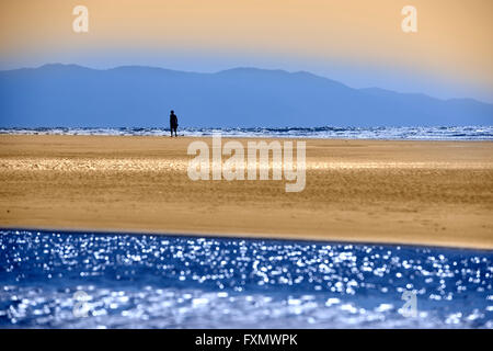 Einziger Mann am mexikanischen Strand mit bunten Pazifischen Ozean und Sierra Madre Berge Nuevo Vallarta Mexiko blau und orange Stockfoto