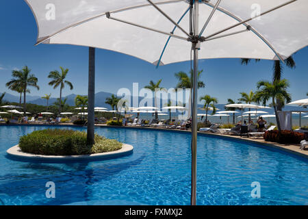 Unter einem Sonnenschirm am Pool am Pazifischen Ozean mit Sierra Madre Berge Mexiko Stockfoto