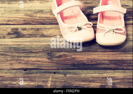 Mädchen Schuhe über Holzdeck Boden. gefilterten Bild. Stockfoto