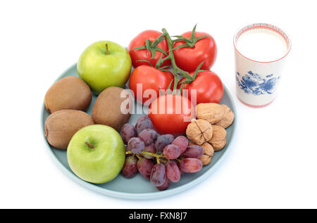 Auswahl an Obst, Walnüsse, Tomaten und ein Glas Milch Stockfoto