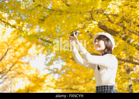 Junge Japanerin mit Vintage-Kamera in einem Stadtpark Stockfoto