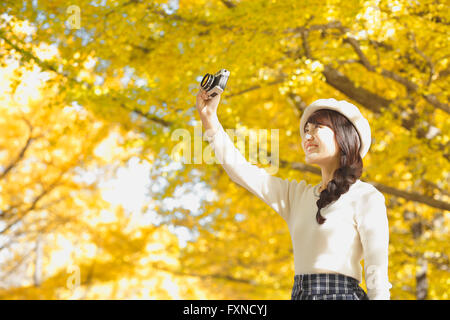 Junge Japanerin mit Vintage-Kamera in einem Stadtpark Stockfoto