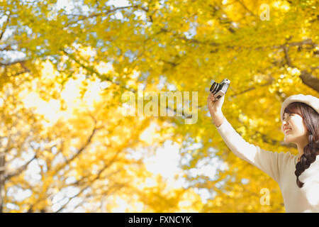 Junge Japanerin mit Vintage-Kamera in einem Stadtpark Stockfoto