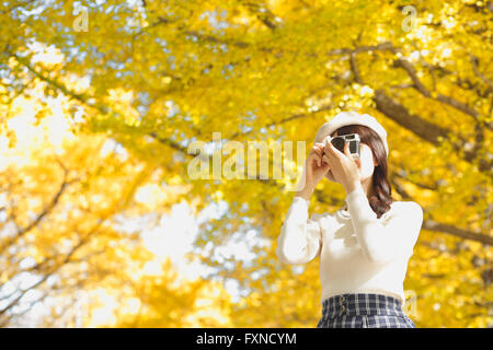 Junge Japanerin mit Vintage-Kamera in einem Stadtpark Stockfoto
