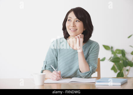 Ältere Japanerin Buchhaltung im Wohnzimmer zu tun Stockfoto
