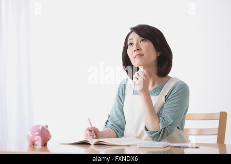 Ältere Japanerin Buchhaltung im Wohnzimmer zu tun Stockfoto