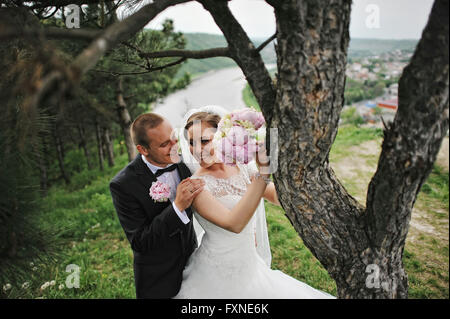 Extravagante Hochzeitspaar in der Nähe von Kiefer umarmt Stockfoto