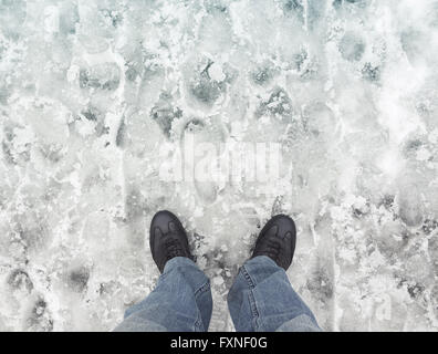 Männliche Füße in neuen Lederschuhe auf nassen schmutzigen verschneiten Straße, Egoperspektive Stockfoto