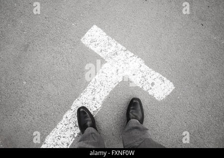 Männliche Füße in neuen schwarz glänzende Lederschuhe stehen auf Asphaltdecke mit Parkplatz Straße Kennzeichnung, Egoperspektive Stockfoto