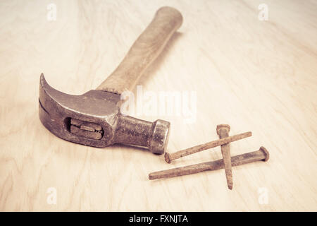 Alte hölzerne Hammer und quadratischen Nägel auf Holz Hintergrund. Stockfoto