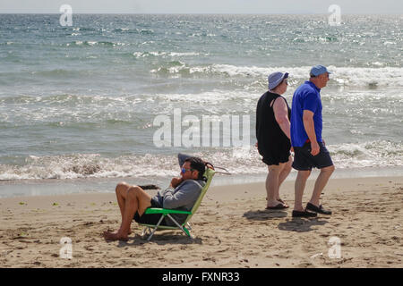 Älteres Ehepaar bei einem Spaziergang entlang des Strandes in Spanien, bei bewölktem Wetter. Andalusien, Spanien. Stockfoto