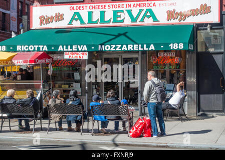 Touristen in Little Italy Snacks zu essen, auf den Bänken außerhalb Alleva italienischen Deli in New York City Stockfoto