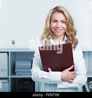 Glücklich blonde Frau mit Lebenslauf und Lebenslauf im Büro Stockfoto