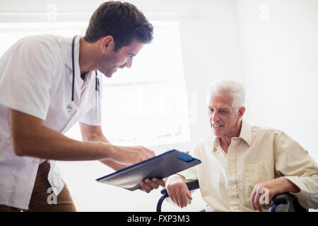 Krankenschwester zeigt senior Mann ein Dokument Stockfoto